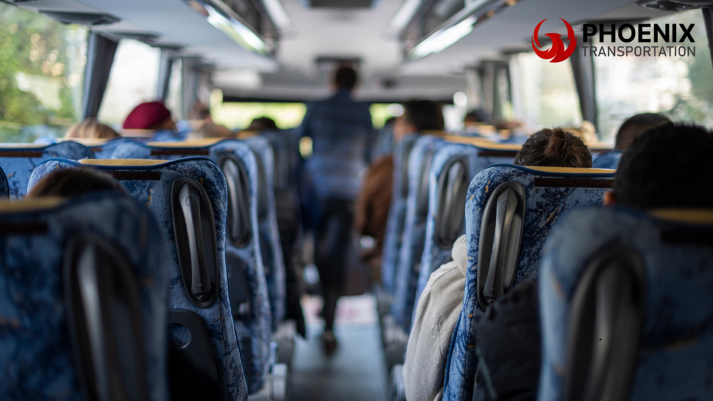 Interior of a bus with passengers seated, seen from behind. The atmosphere is calm, and soft lighting filters through the windows.